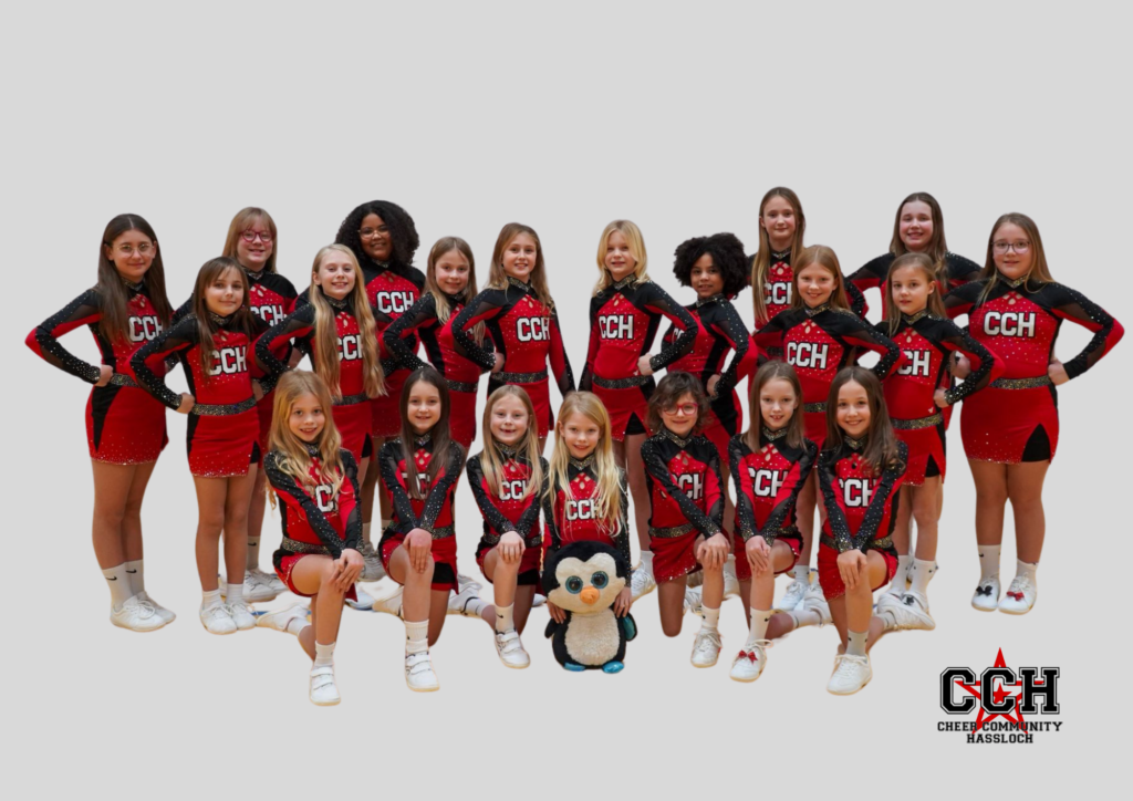 Cheerleading Gruppe in roten und schwarzen Uniformen mit einem Plüschpinguin in der Mitte.